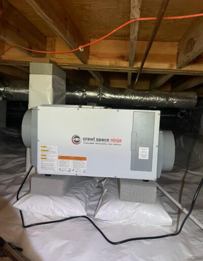 Crawl space dehumidifier installed during crawl space encapsulation along with vapor barrier.